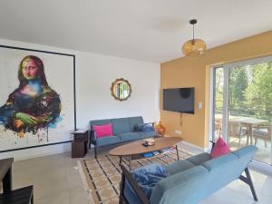a living room with a painting of a woman at Les Villas de l'Ill in Didenheim