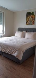 a bedroom with a large bed with white sheets at Шанс in Velingrad