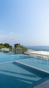 a swimming pool with the ocean in the background at Ilyonis Hotel & Spa in Shëngjin