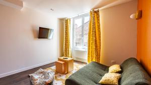 a living room with a couch and a window at Pop Hôtel in Dijon