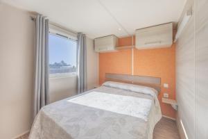 a small bedroom with a bed and a window at Bungalow Tranquilo Cerca de Roche in Conil de la Frontera