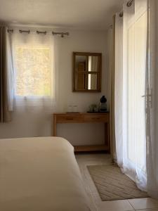 a bedroom with a bed and a window at Chambre 2 dans un petit paradis in La Londe-les-Maures +3 photos