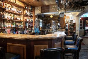 a bar in a pub with a lot of bottles of alcohol at Strands Hotel/Screes Inn & Micro Brewery in Nether Wasdale