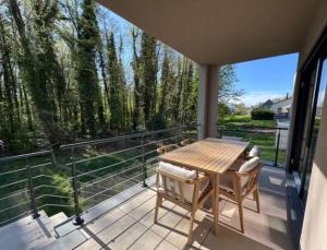 a patio with a table and chairs on a balcony at Les Villas de l'Ill in Didenheim