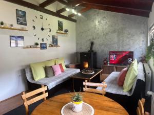 a living room with two couches and a clock on the wall at Kuća za odmor-Aleksandra in Divčibare