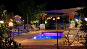 a swimming pool at night with chairs and an umbrella at Glamping la Yurta nel verde Luxe glampingtent in Torino di Sangro