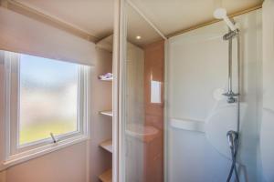 a bathroom with a shower and a window at Bungalow Tranquilo Cerca de Roche in Conil de la Frontera +20 photos
