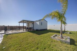 a tiny house in a yard with a palm tree at Bungalow Tranquilo Cerca de Roche in Conil de la Frontera
