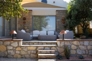 a stone retaining wall with a couch in front of a house at Odette Pansiyon Bodrum in Bodrum City