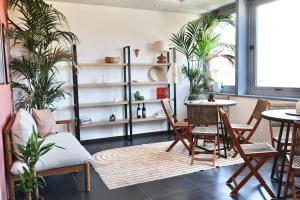a living room with plants and a table and chairs at TAGA Rooms in Catania