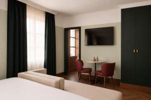 a hotel room with a bed and a table with chairs at Honest Granada Hotel in Granada