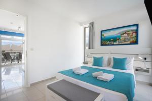 a white bedroom with a large bed with blue accents at Apartment Kreta in Strandnähe in Pilalímata +20 photos