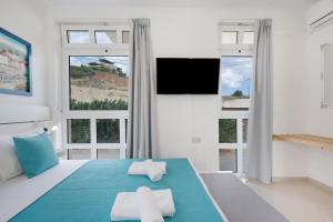 a bedroom with two towels on a bed with windows at Apartment Kreta in Strandnähe in Pilalímata