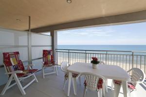 Playa de MiramarにあるApartamento Pilesの白いテーブルと椅子、海を望むバルコニー