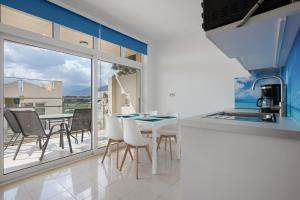 a kitchen with a table and chairs and a balcony at Apartment Kreta in Strandnähe in Pilalímata