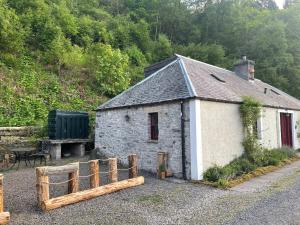 a small building with a fence in front of it at Yairbrig Cottage in Galashiels