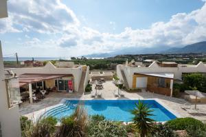 a villa with a swimming pool and a house at Apartment Kreta in Strandnähe in Pilalímata