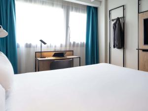 a bedroom with a bed and a desk and a window at ibis Paris Gare de Lyon Diderot in Paris