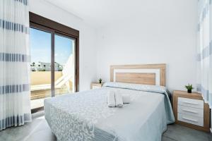 a bedroom with a bed with two towels on it at Bungalow Fausto Sunrise in Orihuela Costa