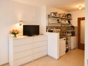 a kitchen with a tv on a white cabinet at Ferienappartement Greta in Lechbruck +4 photos