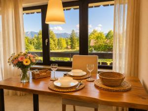 a dining room table with a view of a window at Ferienappartement Greta in Lechbruck