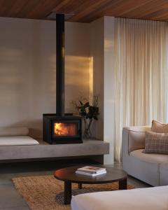 a living room with a fireplace in a room at Sister's Sanctuary in Raglan
