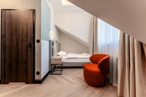a small room with a bed and a chair at Art Queen Aparthotel in Krakow
