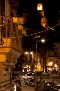 a city street at night with a clock tower at Modica Suite in Modica