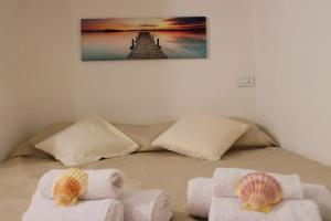 a bed with two towels and a picture on the wall at Piombino Monolocale Poseidonia in Piombino