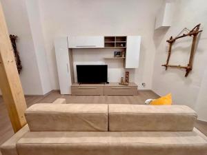a living room with a couch and a television at Piombino Monolocale Poseidonia in Piombino