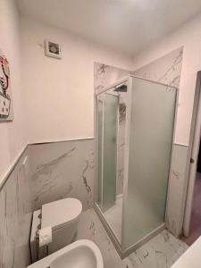 a bathroom with a toilet and a glass shower at Piombino Monolocale Poseidonia in Piombino +19 photos