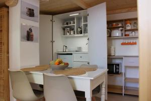 a kitchen with a table with chairs and a bowl of fruit at Piombino Monolocale Poseidonia in Piombino