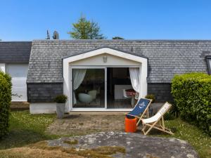 a house with a window and a chair in the yard at Ker Envor in Pleumeur-Bodou