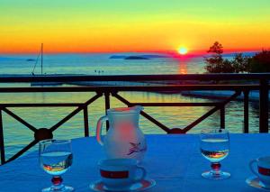 une table avec deux verres d'eau et un vase dans l'établissement Anna Maria - Vanessa Apartments, à Neo Klima