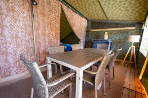 a table and chairs in a tiny house at Duynlodge Ameland direct aan het strand in Nes +6 photos