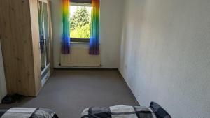 an empty room with a window with rainbow curtains at Ferienwohnung Neckarsulm Mitte in Neckarsulm