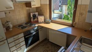 a small kitchen with a stove and a window at Ferienwohnung Neckarsulm Mitte in Neckarsulm