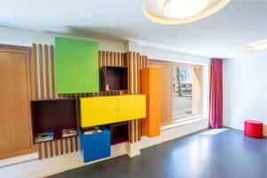 a living room with a tv and a colorful wall at Jugendherberge Ravensburg in Ravensburg