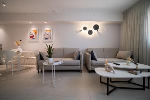 a living room with a couch and tables and chairs at סי סייד אילת - Sea Side Eilat in Eilat