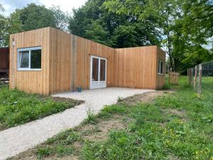 a small wooden building with a door in a yard at Le pré du bonheur in Saint-Georges-sur-Baulche