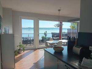 a kitchen with a view of the water and a table at Lagrette Ferienwohnung am Hainer See in Neukieritzsch