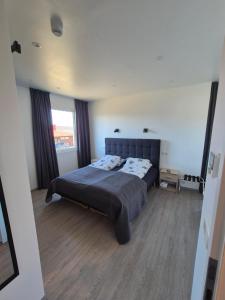 a bedroom with a bed and a large window at Vestmannsvatn Guesthouse in Aðaldalur