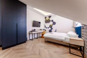 a bedroom with a bed and a desk and a tv at Art Queen Aparthotel in Krakow
