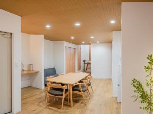 a dining room with a wooden table and chairs at HOTEL Itsuki in Onomichi