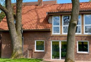 ein Backsteinhaus mit Bäumen davor in der Unterkunft Hof Husmann in Extertal