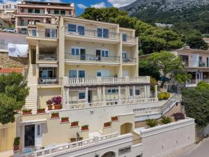 an apartment building with balconies on a hill at Villa King Apartments in Brela