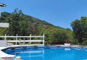 a swimming pool with a white fence and a mountain at B & B Villa Matisse in Laureana Cilento