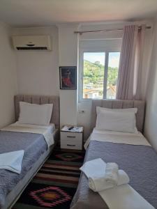 two beds in a room with a window at Villa Noah in Berat