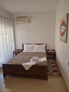 a bedroom with a bed with two towels on it at Villa Noah in Berat