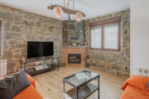 a living room with a stone wall at El Trillo in Marlín